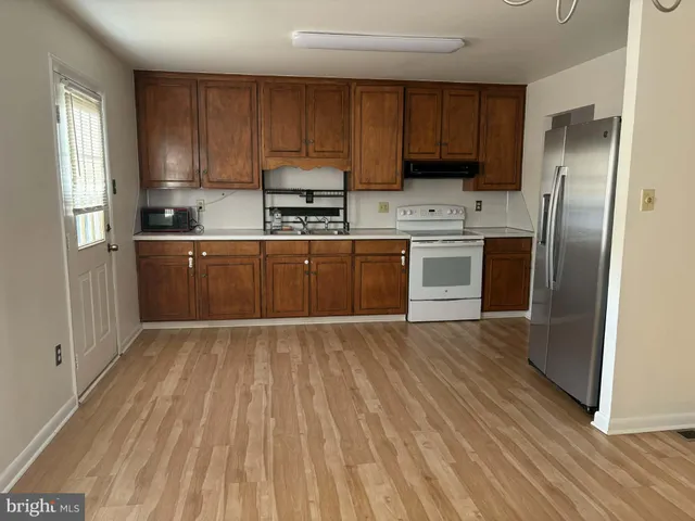 a kitchen with a refrigerator stove top oven and sink