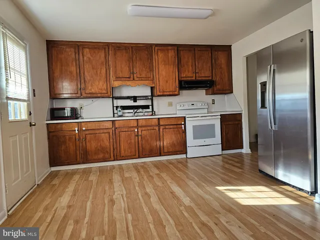 a kitchen with wooden cabinets and stainless steel appliances