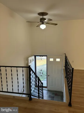 a view of a hallway with wooden floor and staircase