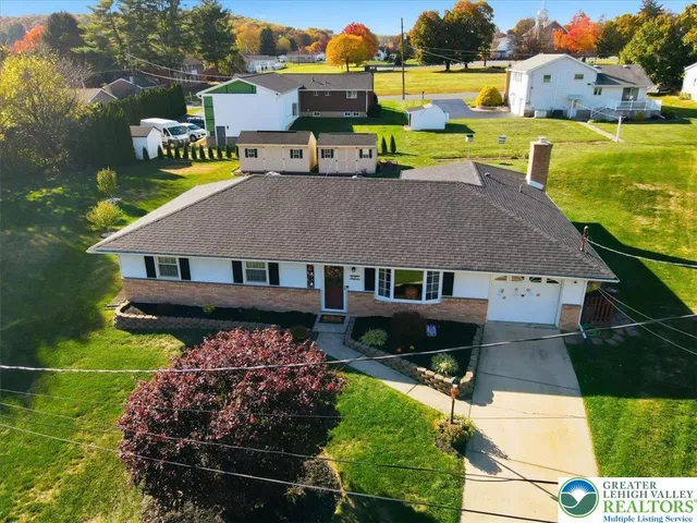 an aerial view of a house with garden space and street view