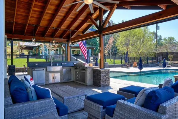 a view of a house with backyard and sitting area