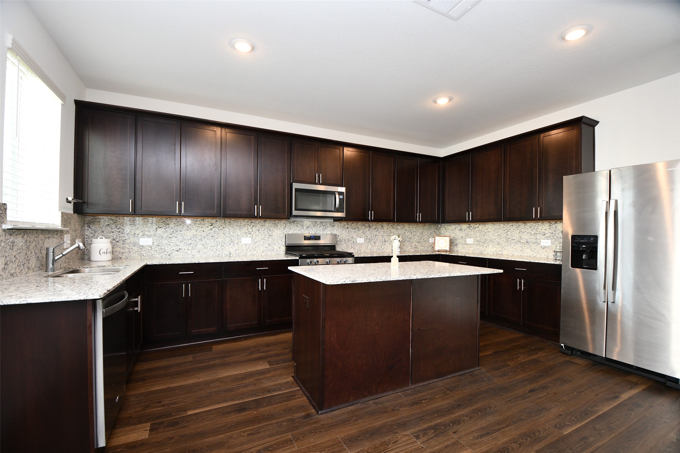 7329 Madison Commons Lane Houston, TX 77075 - Photo 11 of 22 a kitchen with stainless steel appliances wooden cabinets a sink and a stove