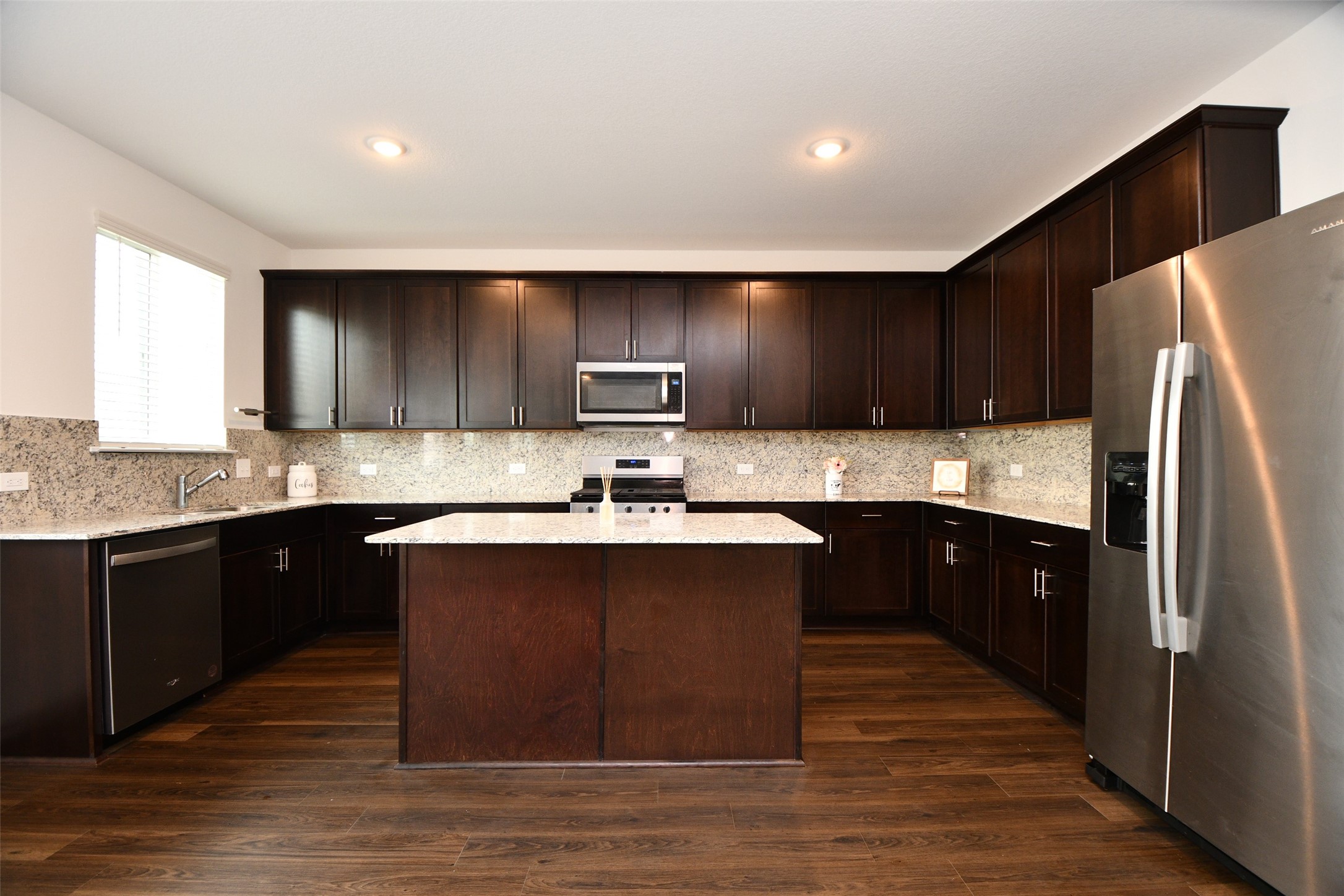 7329 Madison Commons Lane Houston, TX 77075 - Photo 9 of 22 a kitchen with kitchen island granite countertop wooden cabinets a refrigerator and a sink