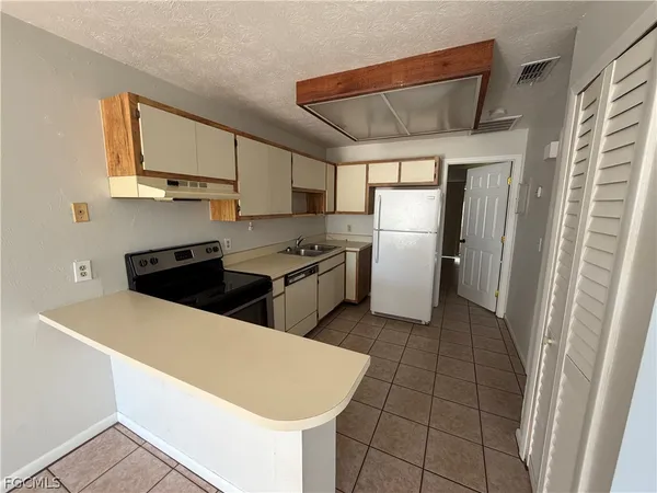 a kitchen with stainless steel appliances a refrigerator sink and microwave