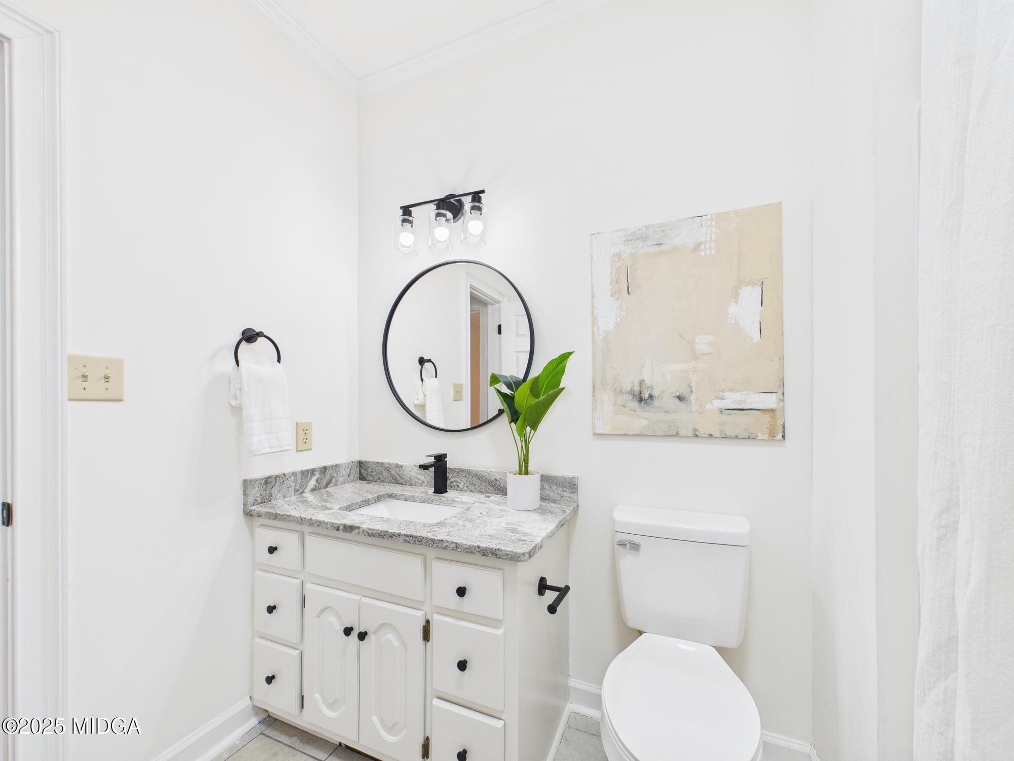 607 Chastain Place Macon, GA 31210 - Photo 29 of 63 a bathroom with a granite countertop toilet sink and mirror
