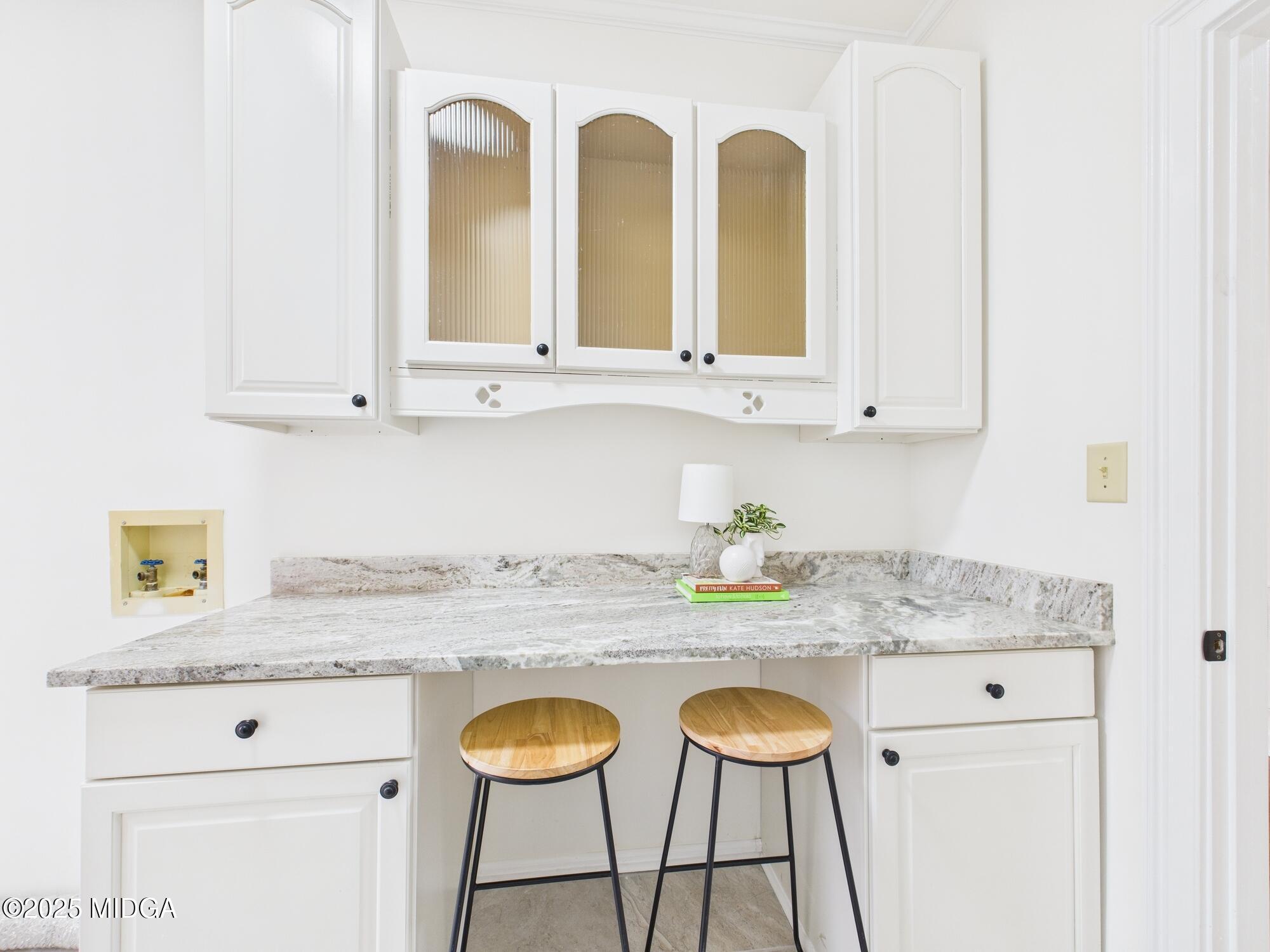 607 Chastain Place Macon, GA 31210 - Photo 36 of 63 a kitchen with stainless steel appliances granite countertop a sink a stove and white cabinets with wooden floor