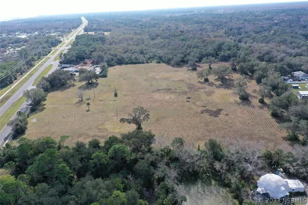 a view of a dry field with lots of bushes