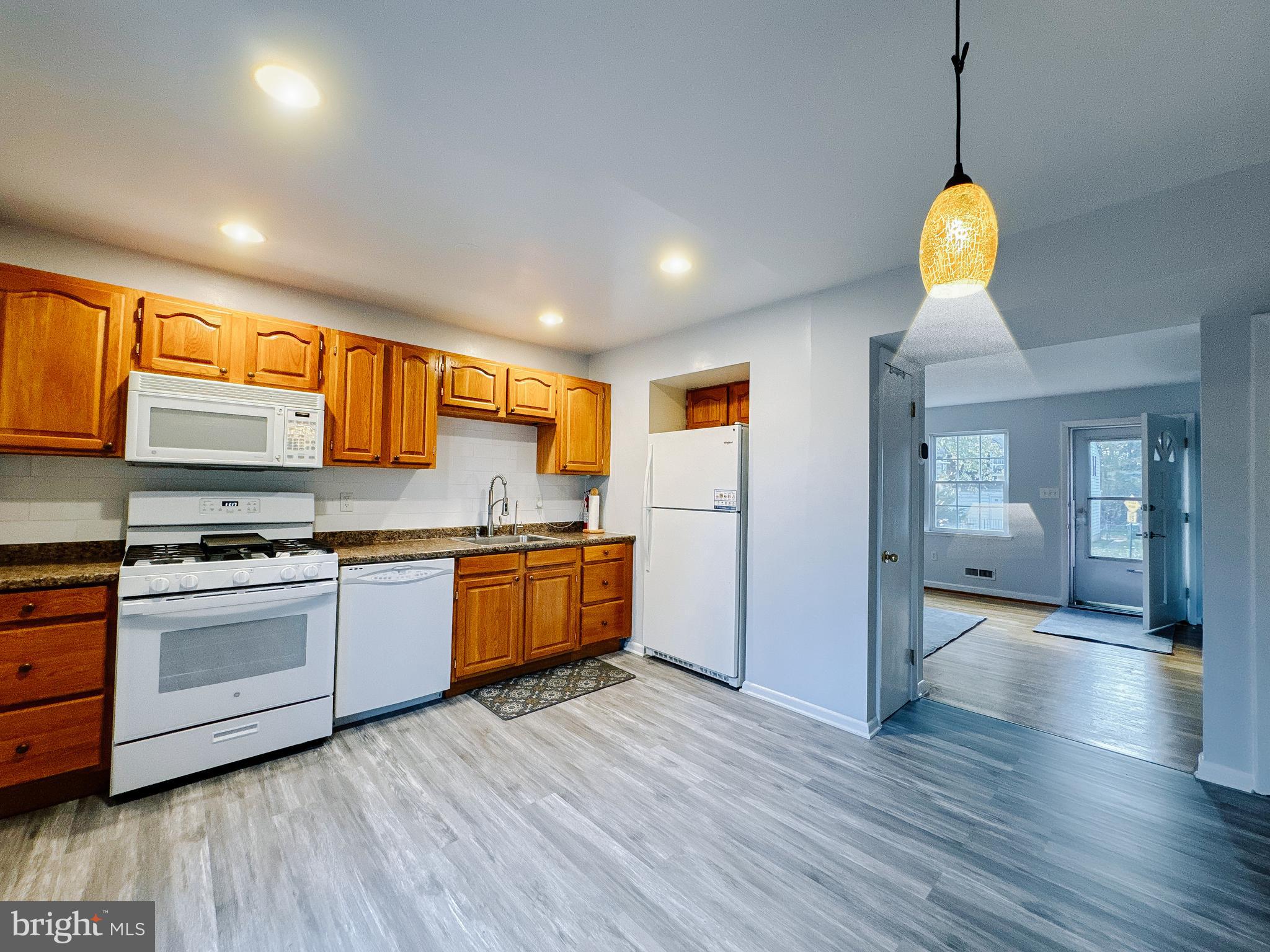 4768 Melbourne Road Baltimore, MD 21229 - Photo 5 of 19 a kitchen with stainless steel appliances granite countertop wooden floors and white cabinets