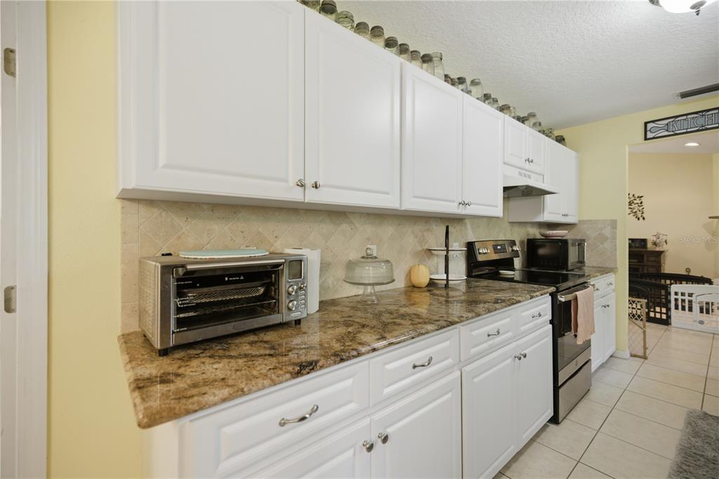 17900 Northwest 120th Avenue Road Reddick, FL 32686 - Photo 43 of 45 a kitchen with stainless steel appliances granite countertop a stove sink and cabinets