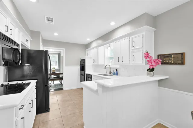 a kitchen with stainless steel appliances a sink a stove a refrigerator and cabinets