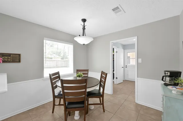 a view of a dining room with furniture and a chandelier fan