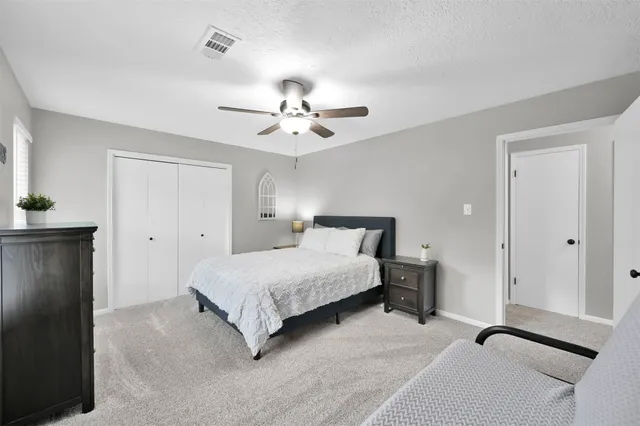 a spacious bedroom with a bed and a ceiling fan