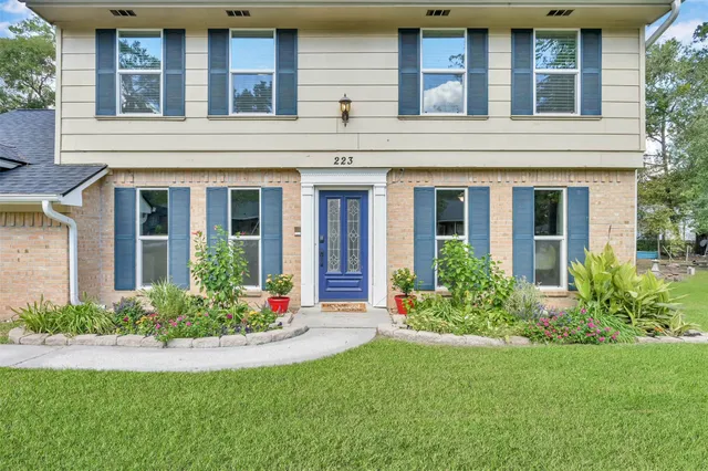 front view of a brick house with a yard