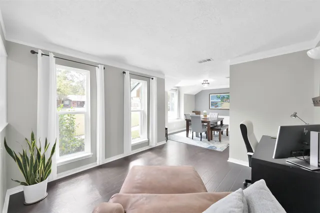a living room with furniture and wooden floor