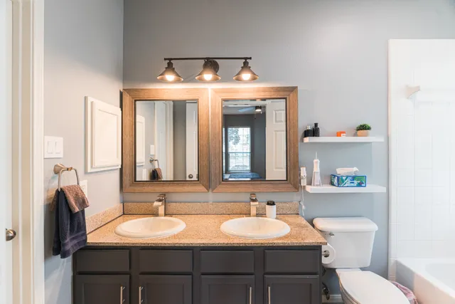 a bathroom with a toilet sink and mirror