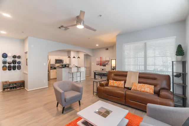 a living room with furniture and view of kitchen