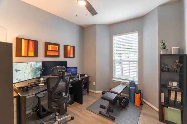 a view of a workspace with furniture and a window