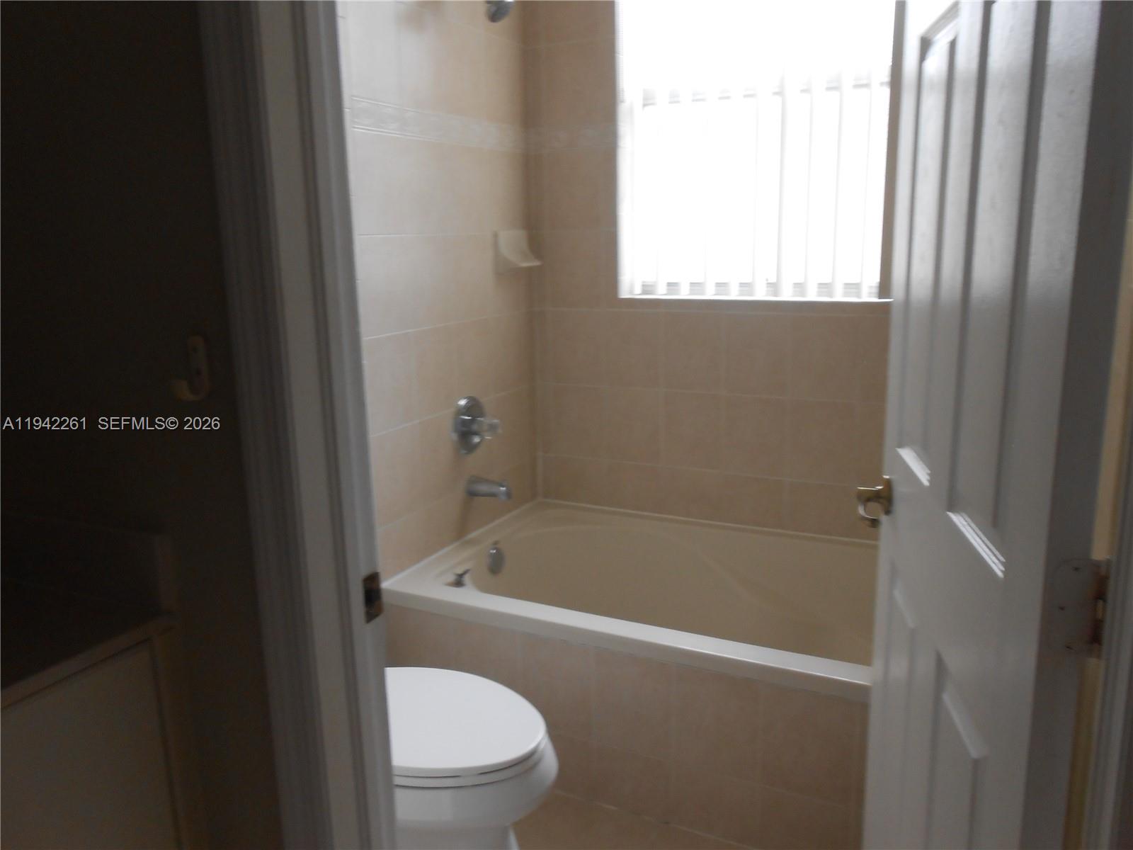 12470 Southwest 122nd Street Miami, FL 33186 - Photo 14 of 26 a white bath tub sitting next to a toilet