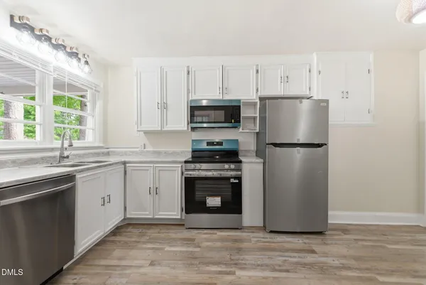 a kitchen with cabinets stainless steel appliances and window