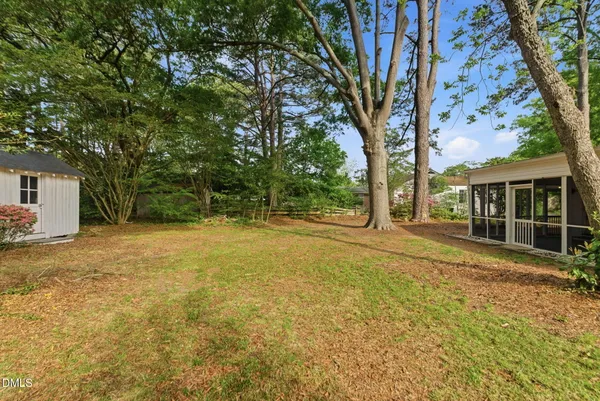 a view of a house with backyard and tree