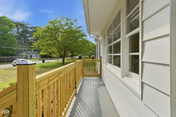 a view of balcony with two large trees and wooden fence