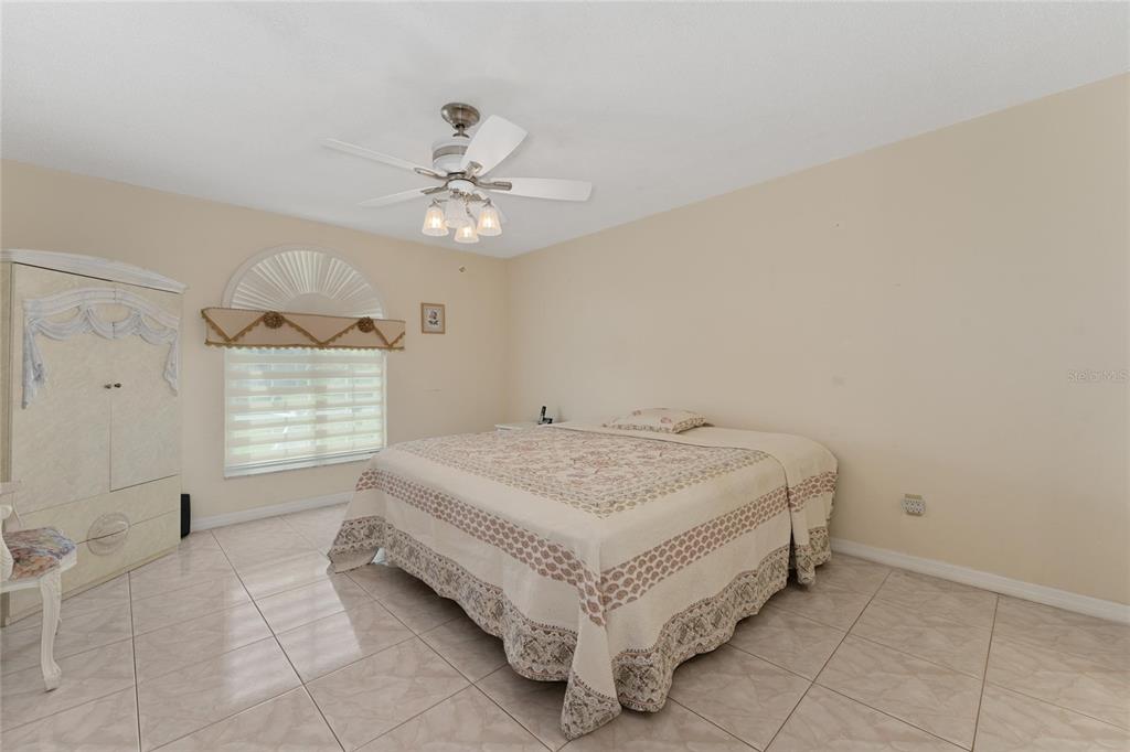 2779 Muscatello Street Orlando, FL 32837 - Photo 17 of 36 a spacious bedroom with a bed and a ceiling fan