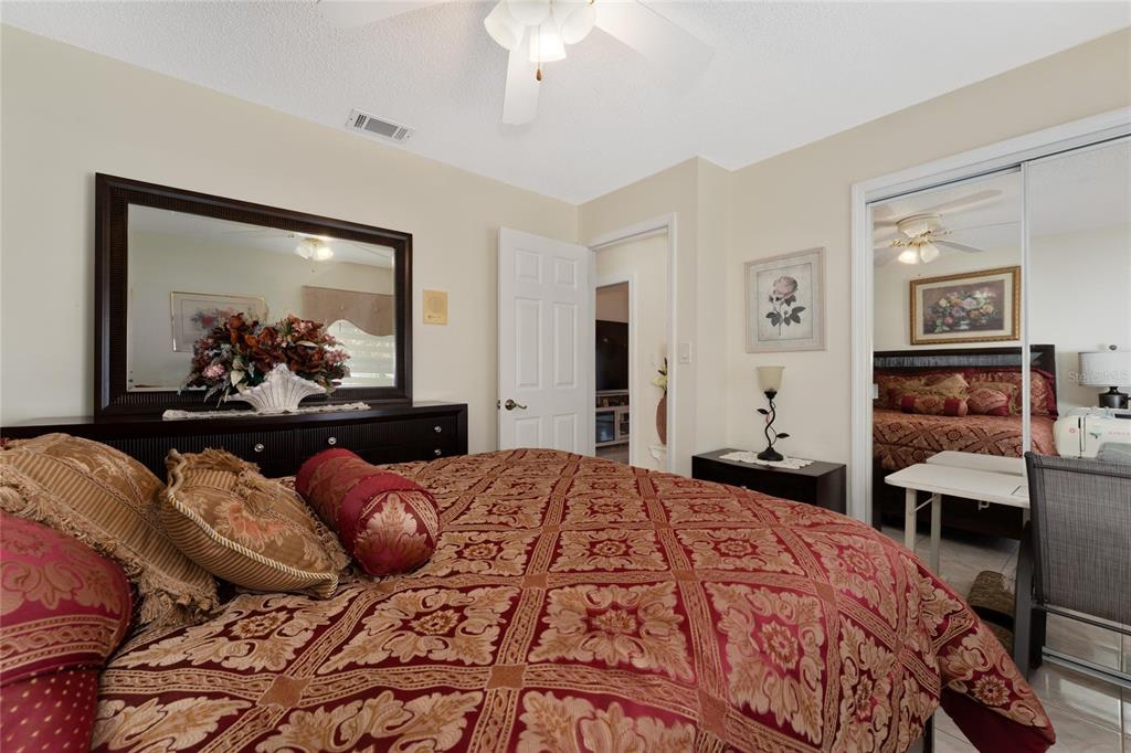 2779 Muscatello Street Orlando, FL 32837 - Photo 25 of 36 a bedroom with a bed and a large mirror with a dresser