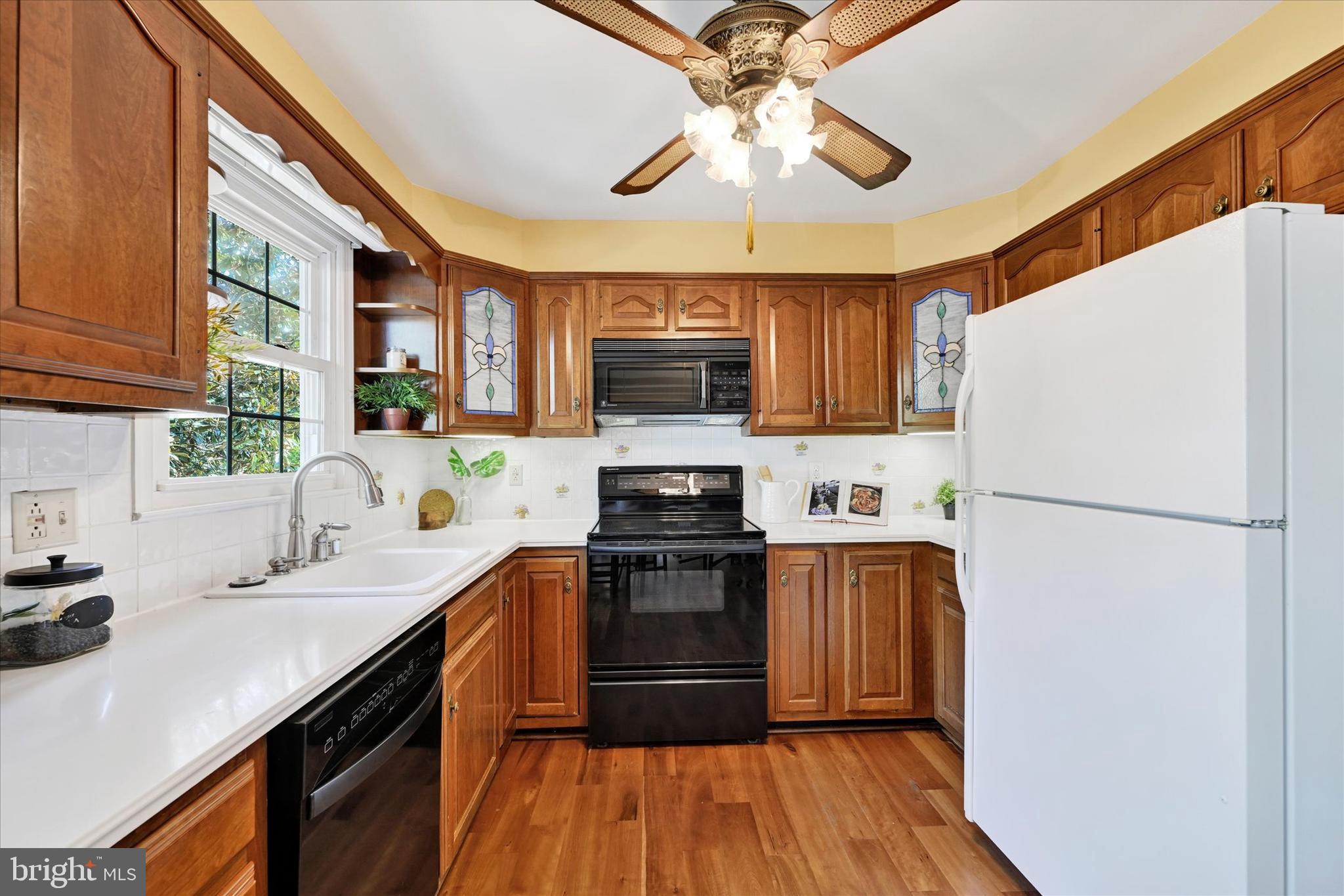 9115 Kilbride Road Baltimore, MD 21236 - Photo 12 of 61 a kitchen with a refrigerator a stove cabinets and a wooden floor