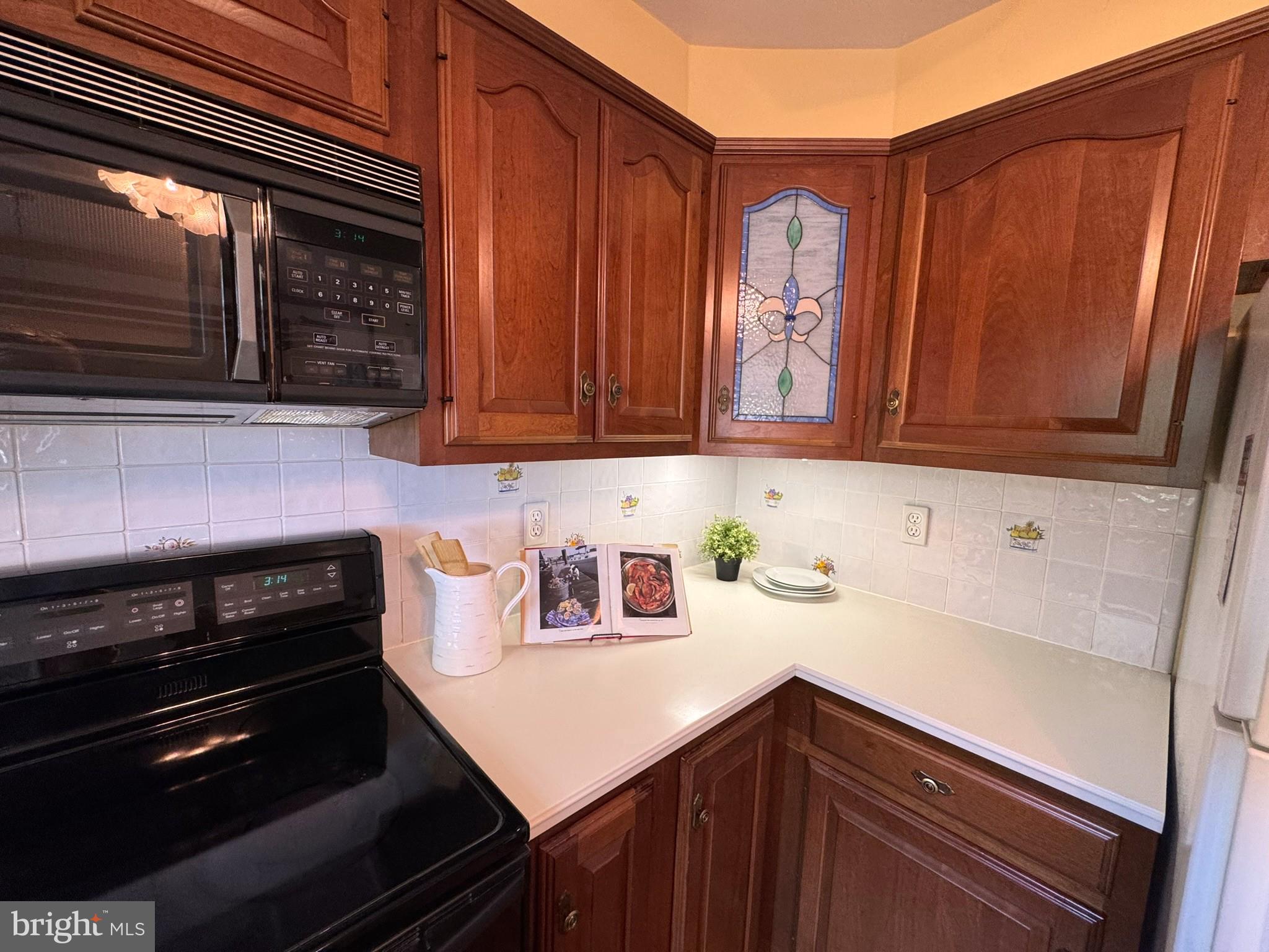 9115 Kilbride Road Baltimore, MD 21236 - Photo 13 of 61 a kitchen with stainless steel appliances wooden cabinets and a stove top oven