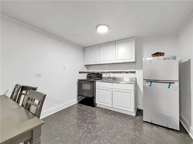 a kitchen with a refrigerator stove and white cabinets