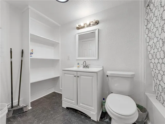 a bathroom with a toilet a sink and mirror