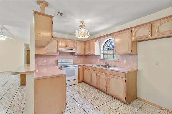 a kitchen with granite countertop a sink stainless steel appliances and cabinets