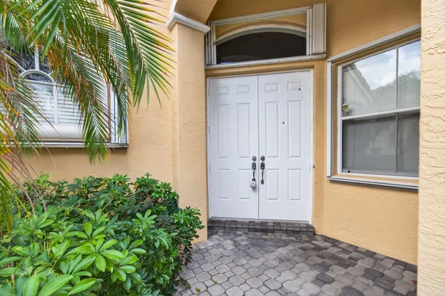 a living room with furniture a large window and potted plants