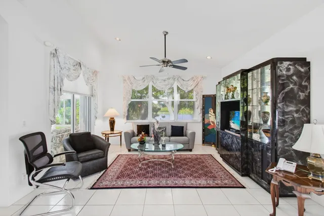 a view of a white house with a yard and palm trees