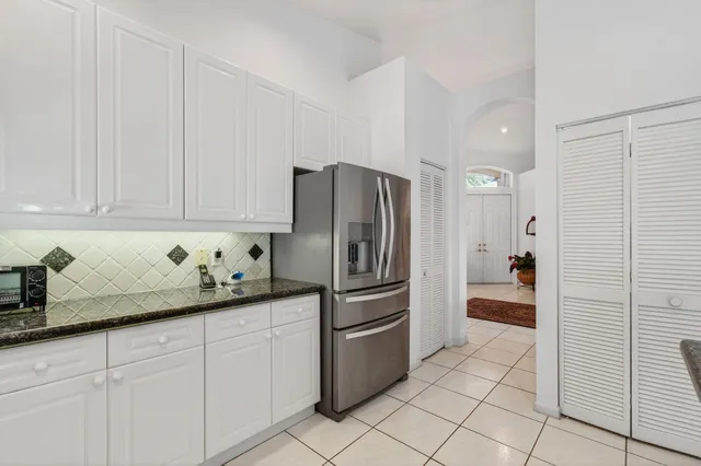 a view of a patio with a table and chairs under an umbrella with potted plants