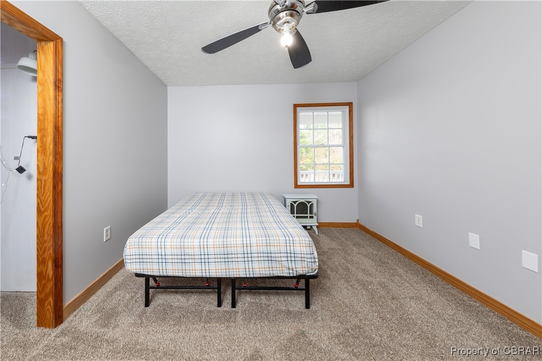 9534 Gee Farm Road Gloucester, VA 23061 - Photo 24 of 48 Bedroom with ceiling fan, carpet, and a textured ceiling