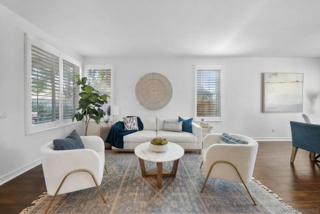 a kitchen with a stove a sink and white cabinets with wooden floor