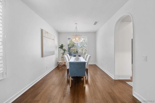 a dining room with furniture a chandelier and wooden floor