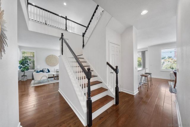 an empty room with wooden floor and ceiling fan