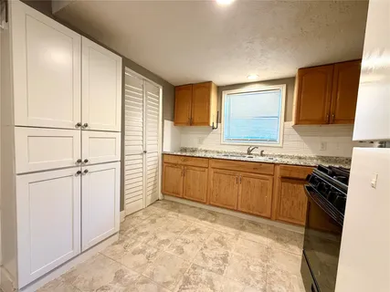 a kitchen with stainless steel appliances granite countertop a stove a sink and a refrigerator
