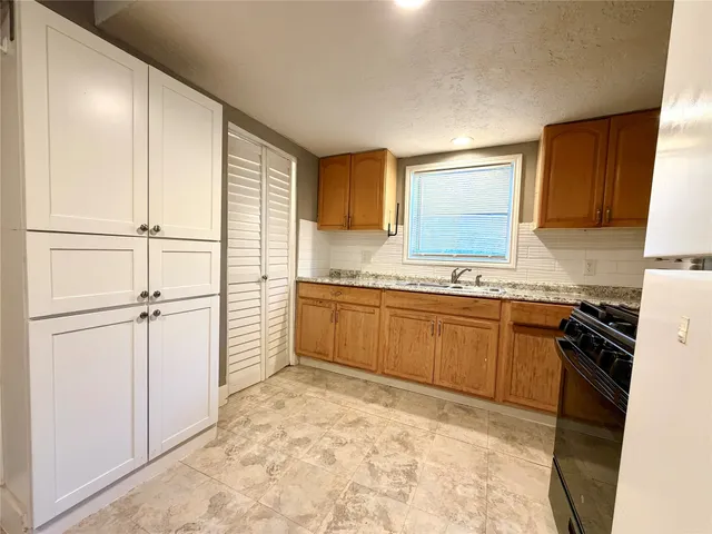 a kitchen with stainless steel appliances granite countertop a stove a sink and a refrigerator