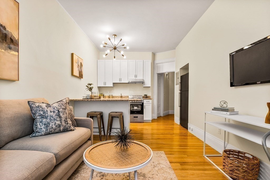 481 Beacon Street, Unit 43 Boston, MA 02115 - Photo 2 of 10 a living room with stainless steel appliances granite countertop a couch a dining table and chairs
