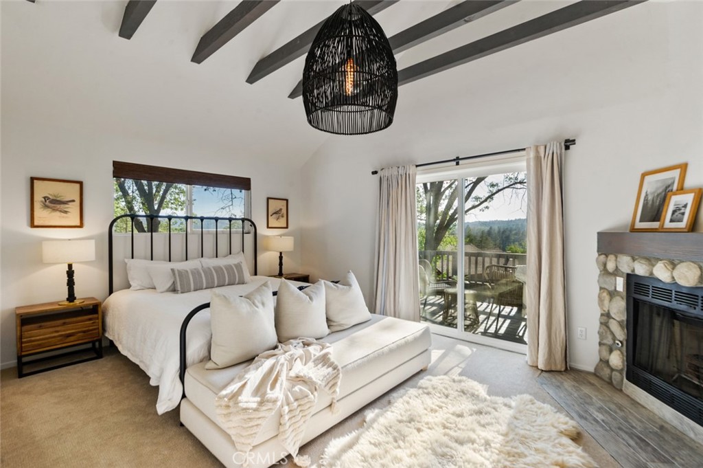 940 Highway 173 Lake Arrowhead, CA 92352 - Photo 15 of 45 a bed room with a bed a fireplace and a large window