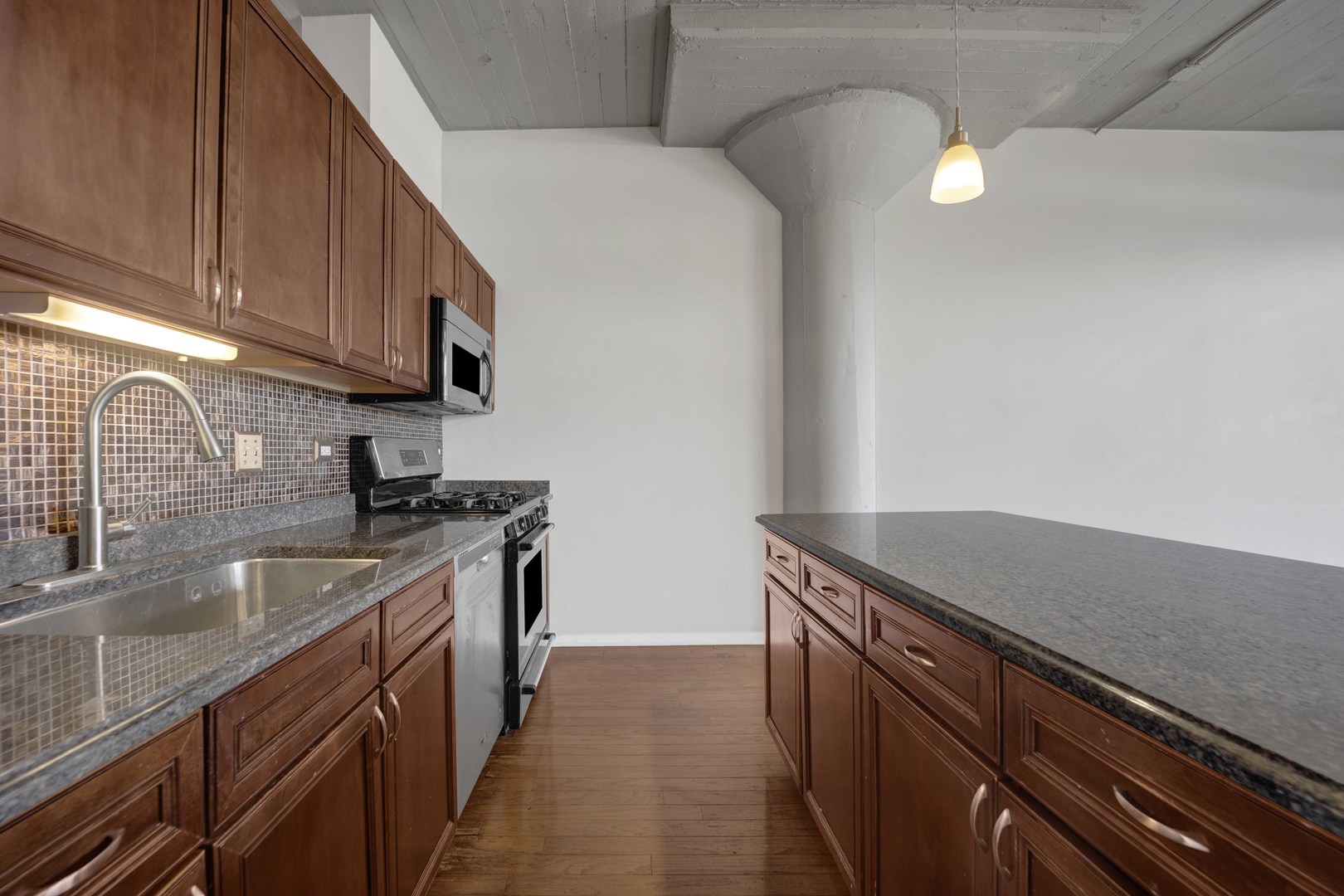 1525 South Sangamon Street, Unit 504 Chicago, IL 60608 - Photo 9 of 32 a kitchen with stainless steel appliances granite countertop a sink and a stove