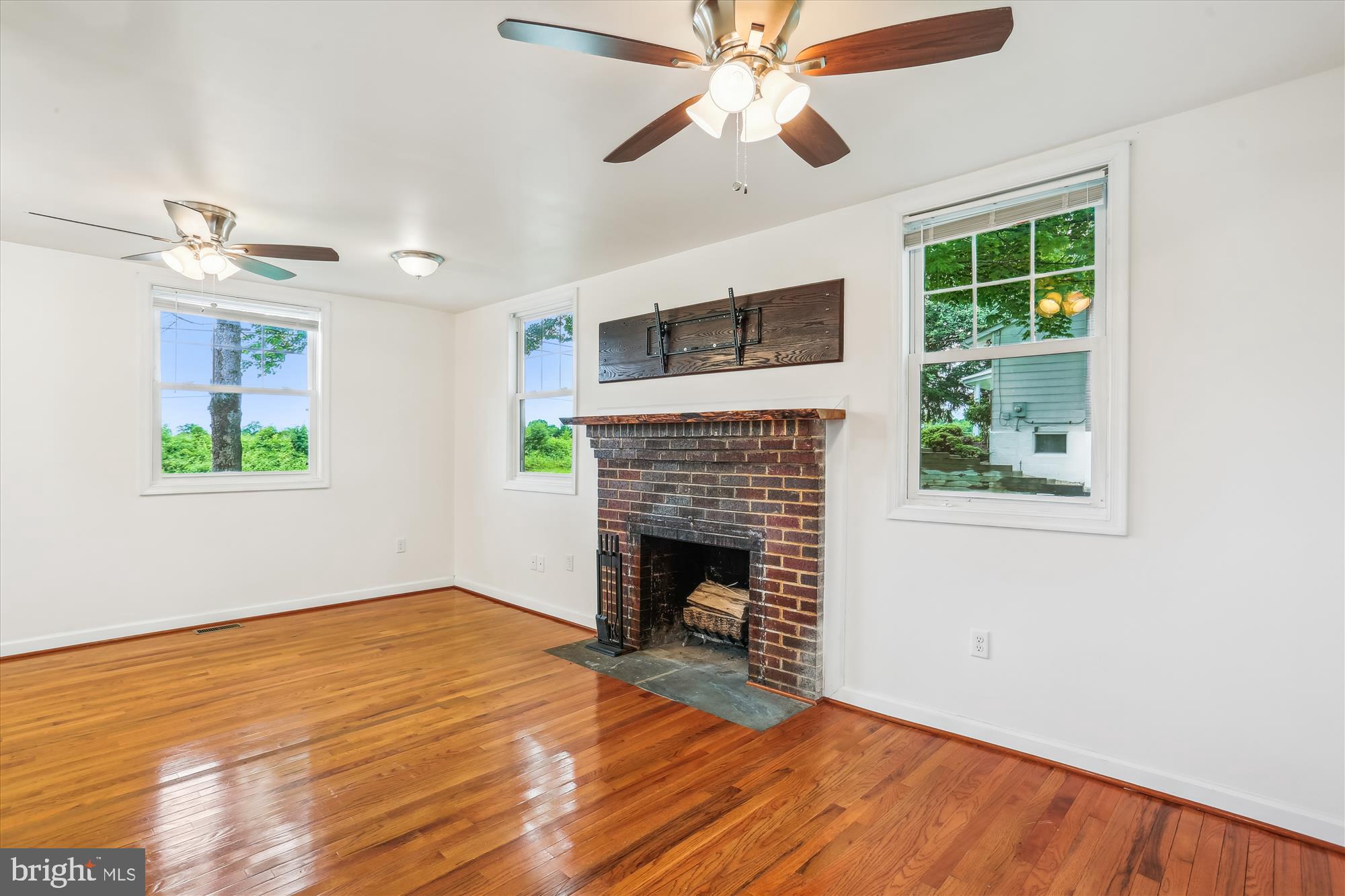 11008 Liberty Road Frederick, MD 21701 - Photo 14 of 39 a view of empty room with wooden floor fireplace and fan