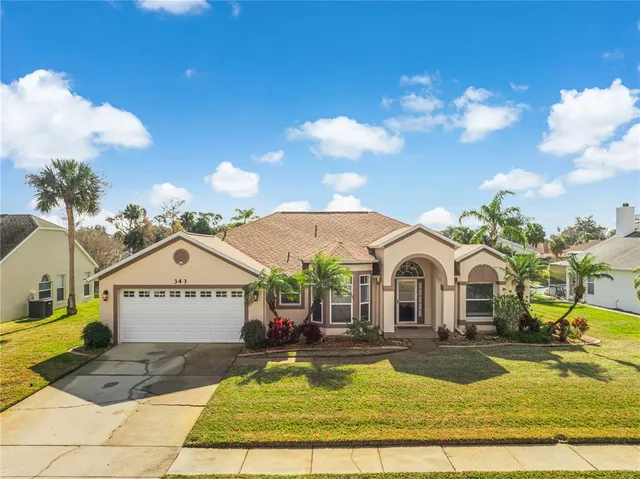 a view of a white house with swimming pool lawn chairs and painted walls