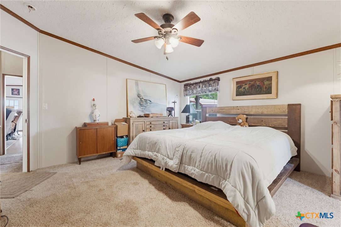 164 County Road 4450 Kempner, TX 76539 - Photo 15 of 44 a bedroom with bed and a chandelier