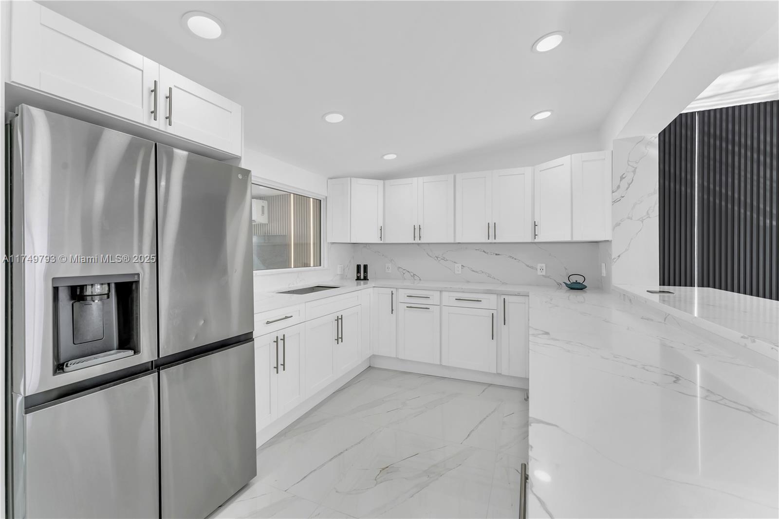 19900 Gulfstream Road Cutler Bay, FL 33157 - Photo 12 of 34 a kitchen with granite countertop white cabinets and stainless steel appliances