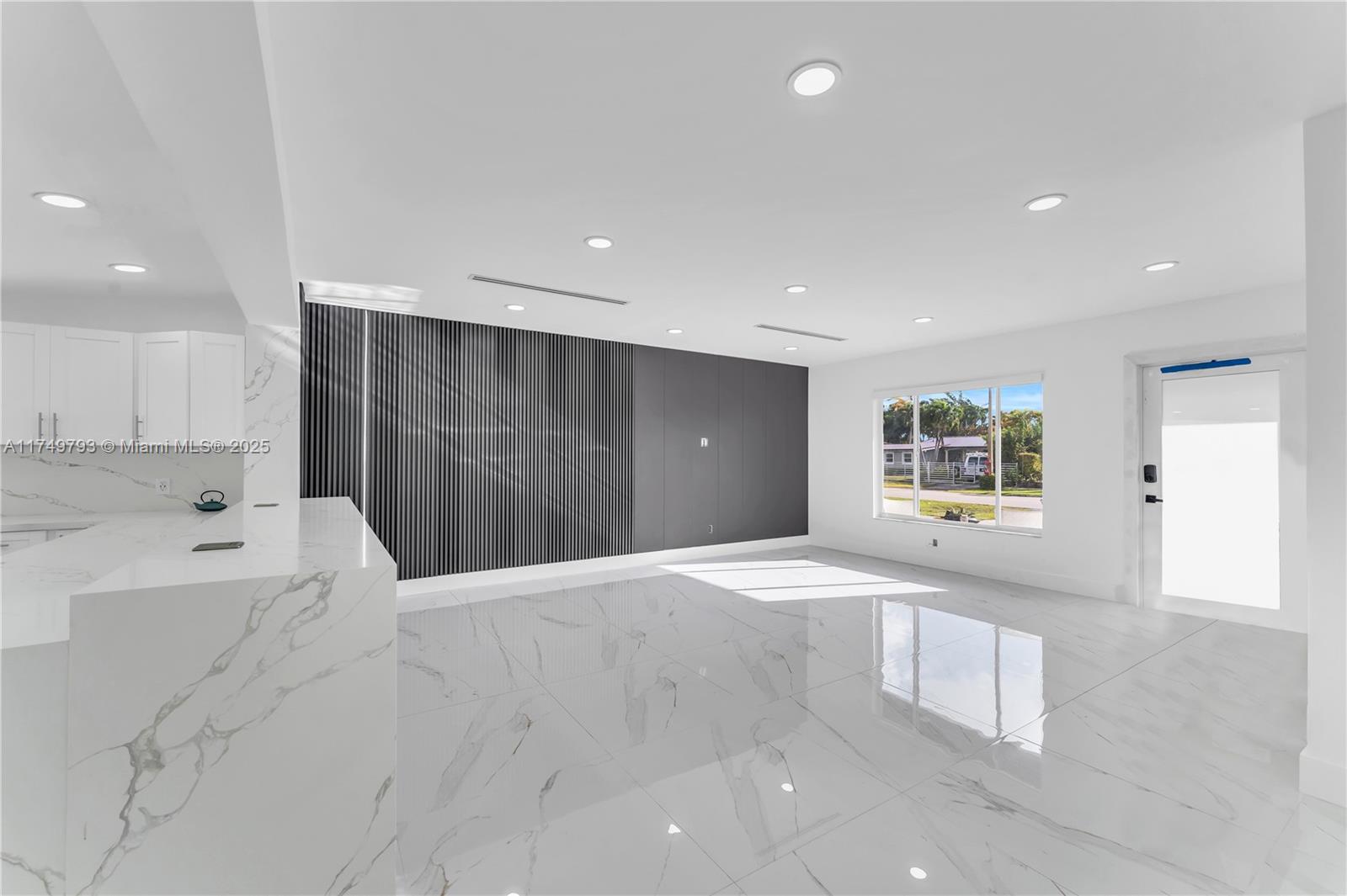 19900 Gulfstream Road Cutler Bay, FL 33157 - Photo 4 of 34 a view of an empty room with wooden cabinet and a window