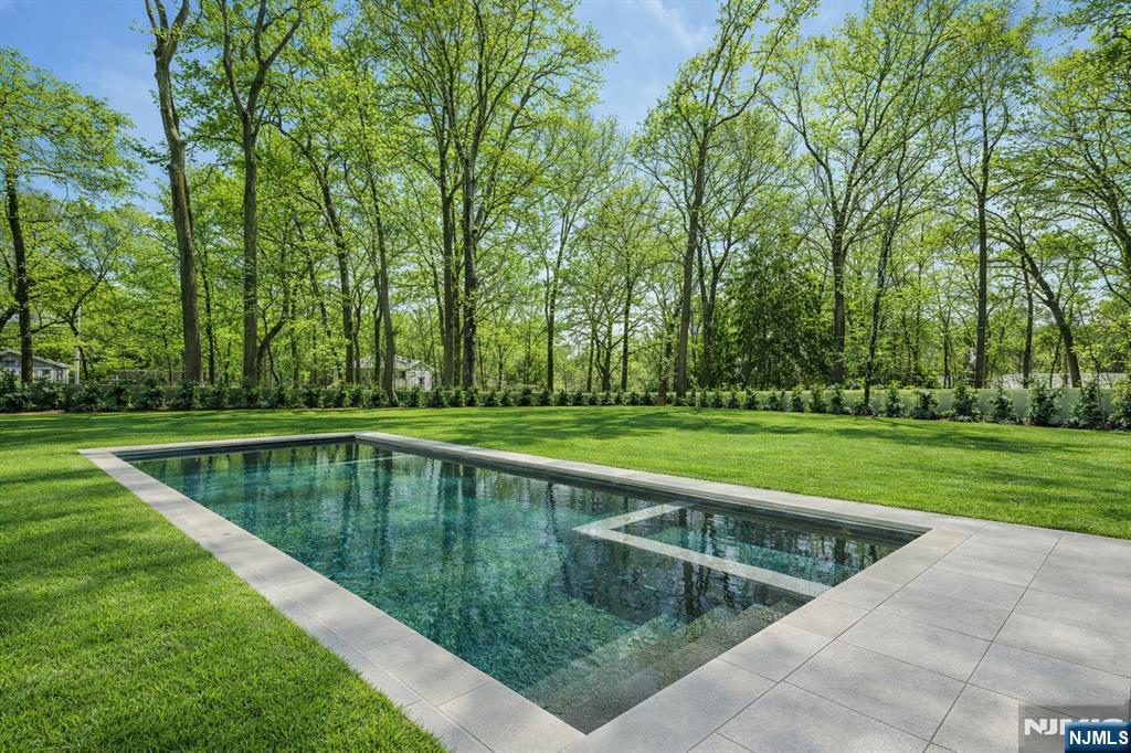 48 Brook Road Upper Saddle River, NJ 07458 - Photo 49 of 50 a view of a swimming pool with a lawn chairs and large trees